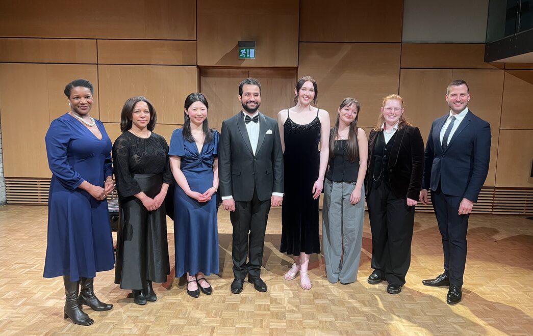 Elizabeth Llewellyn MBE, Tebogo Monnakgotla, Hannah Chiu, Khaled Issa, Rachel Wheatley, Anastasia Gould, Matthew Vining, and Dr Nico de Villiers standing in a line wearing smart clothes and facing the camera