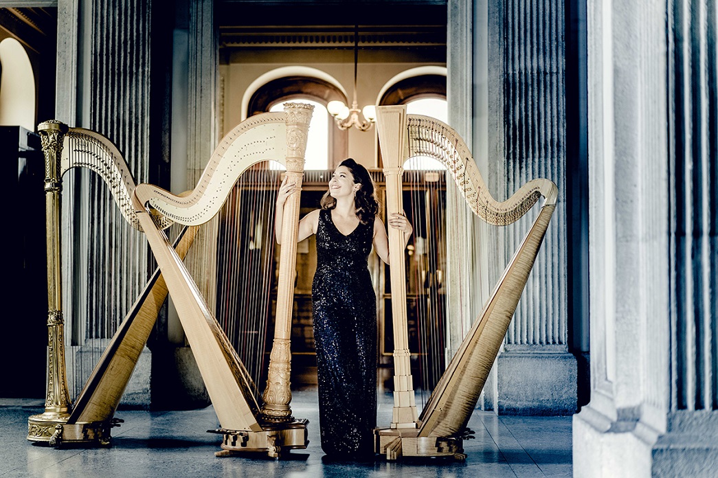 Anneleen Lenaerts standing with two harps