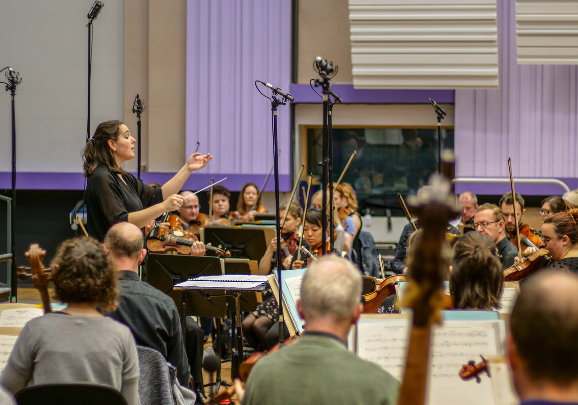 A conductor conducts the BBC Philharmonic Orchestra. 