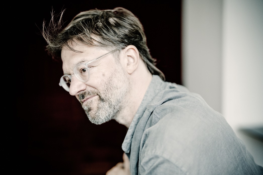 Side profile of Andre de Ridder wearing glasses and a grey shirt