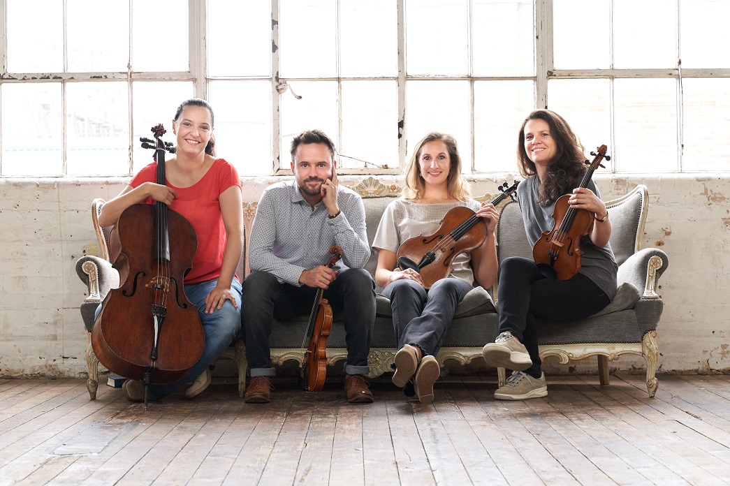 Elias String Quartet sitting on a sofa.