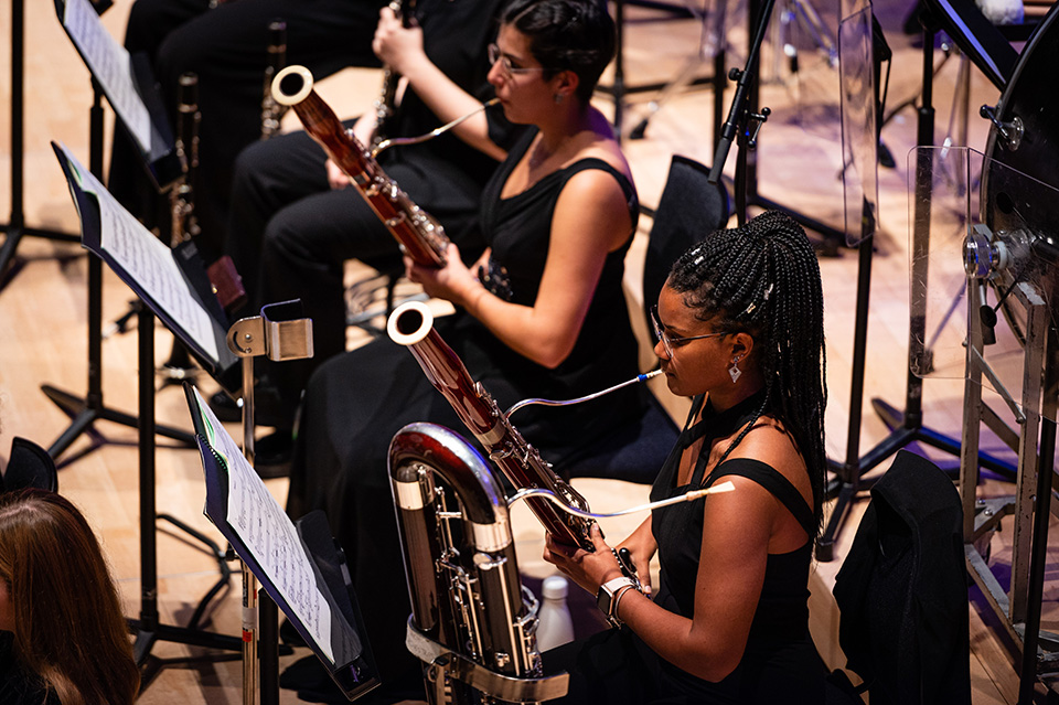 Woodwind musicians play as part of an orchestra. 
