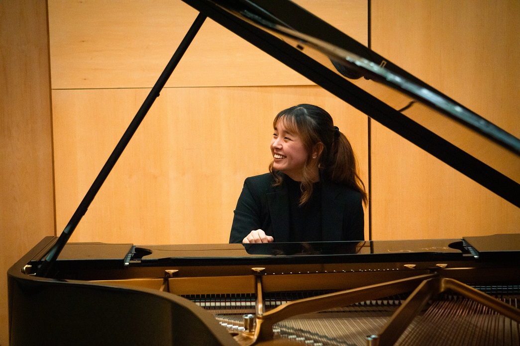 Gema Lu Cai sitting behind a piano