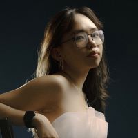 Female with glasses with dark backdrop