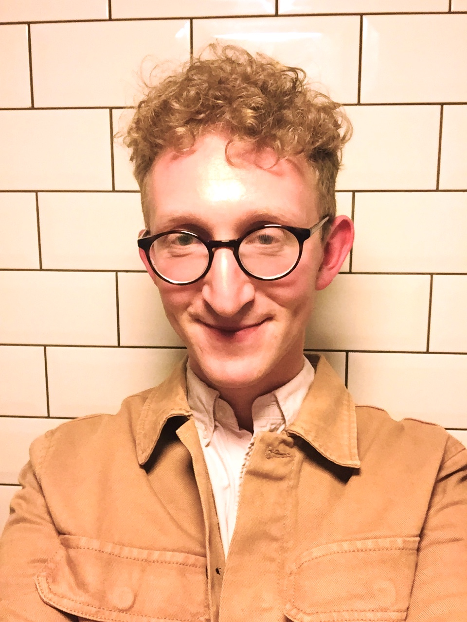 A headshot of a man wearing glasses