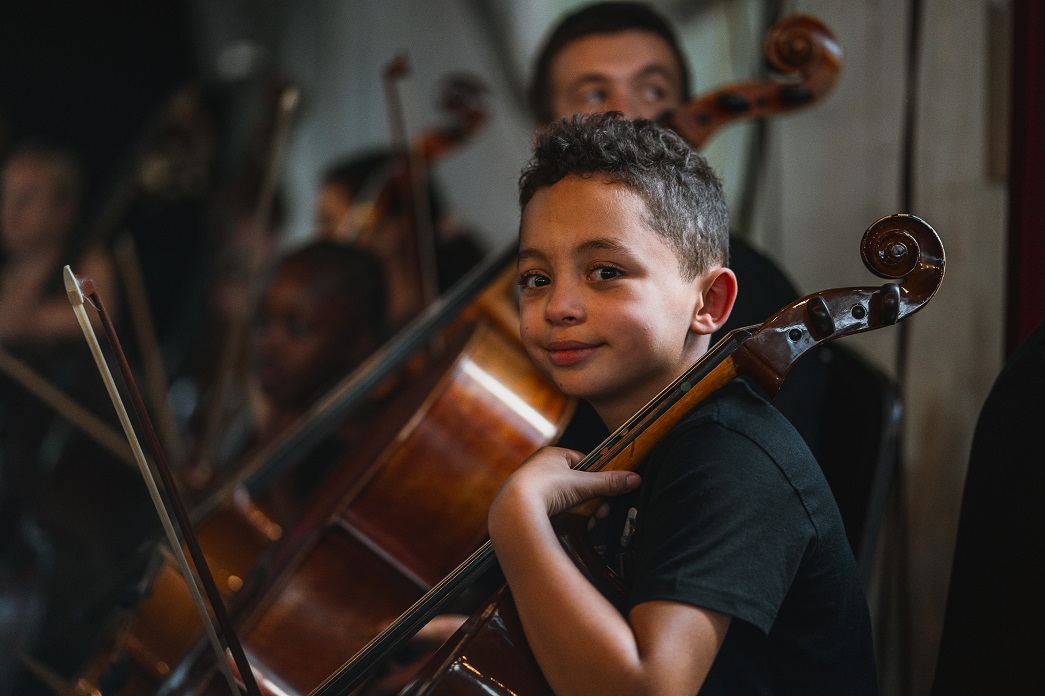 A boy holding a cello