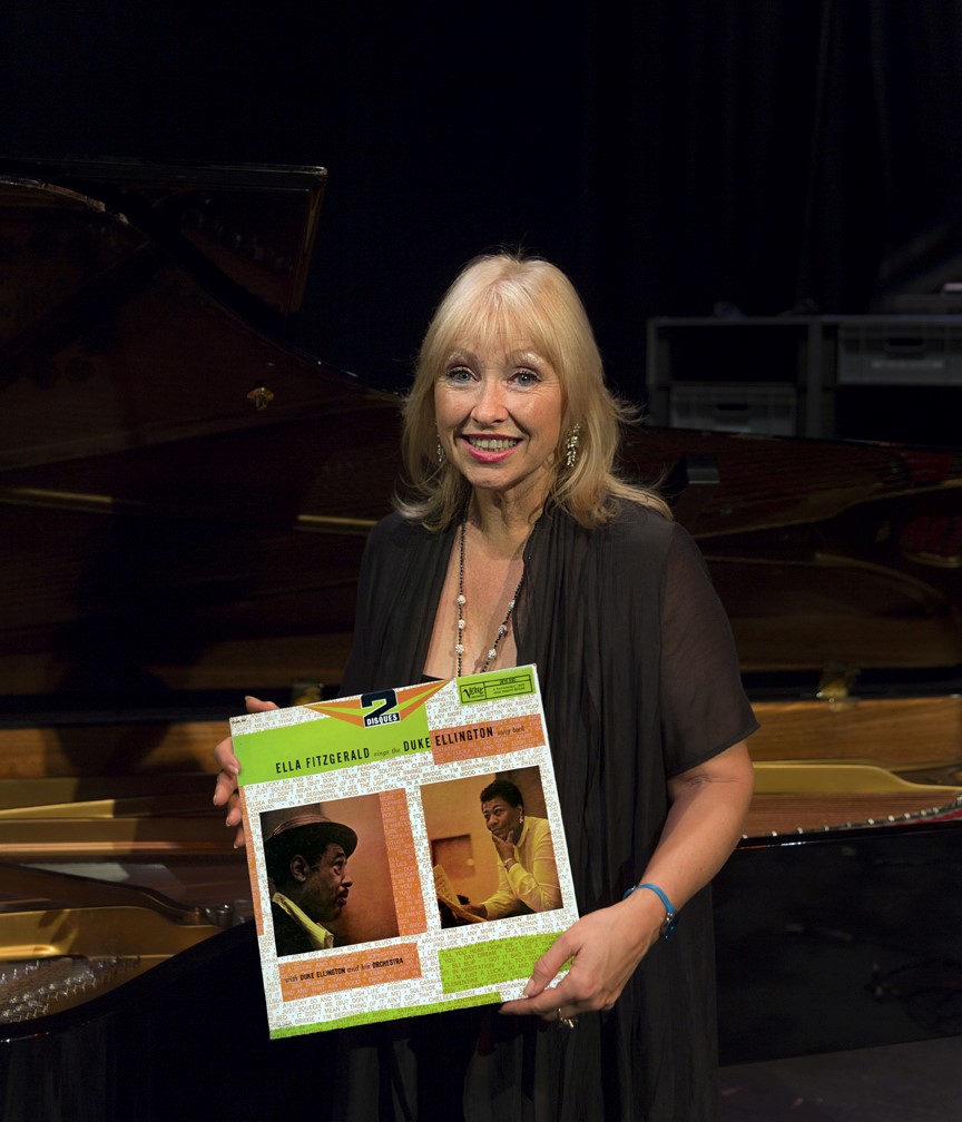 Tina May Holding LP- Ella Fitzgerald Sings the Duke Ellington Songbook in front of a piano.