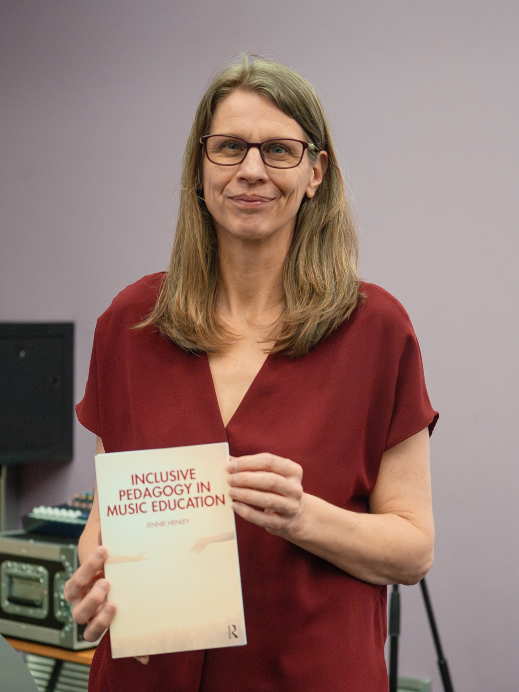 Professor Jennie Henley holding a copy of her book