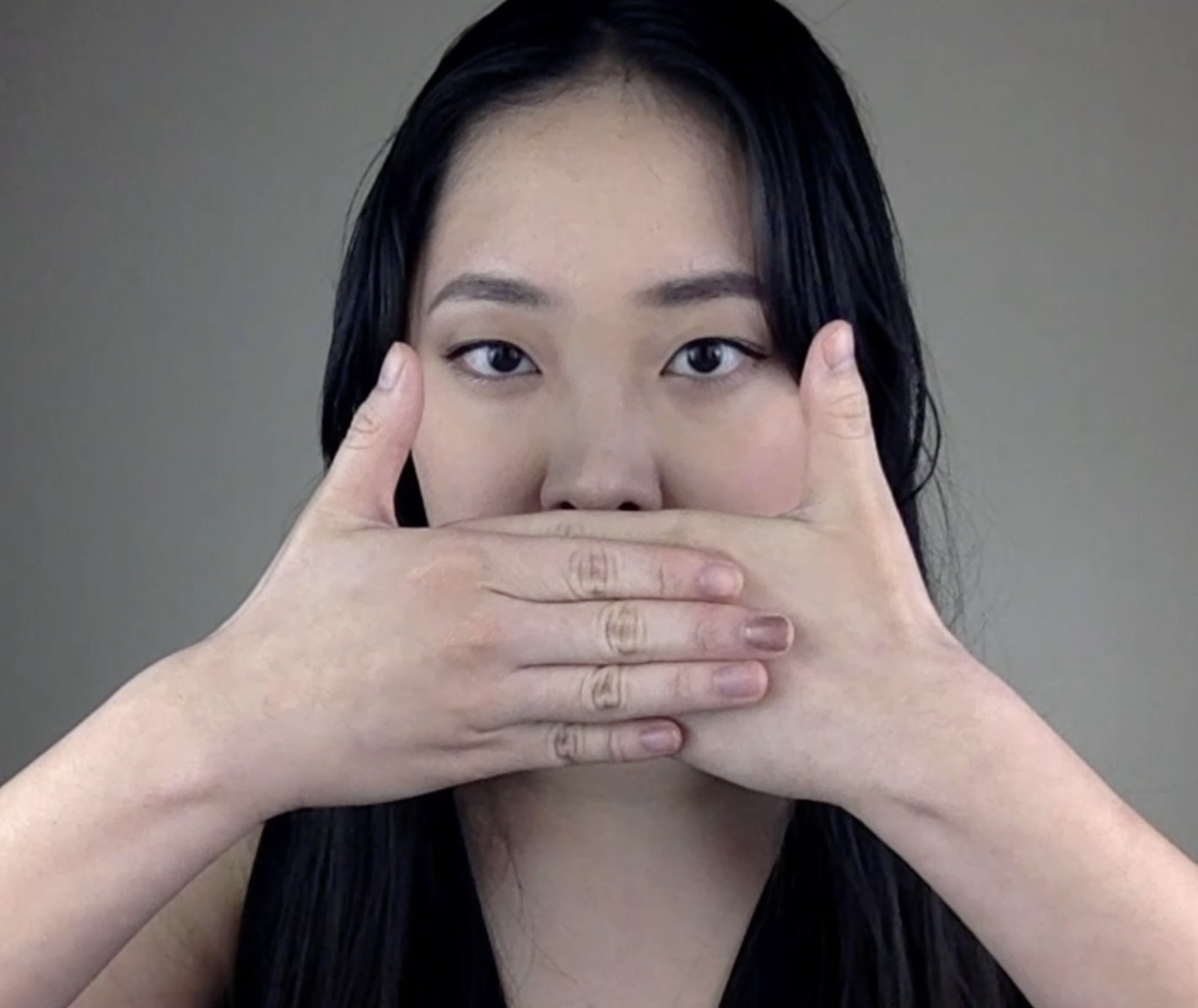 A singer with her hands covering her mouth