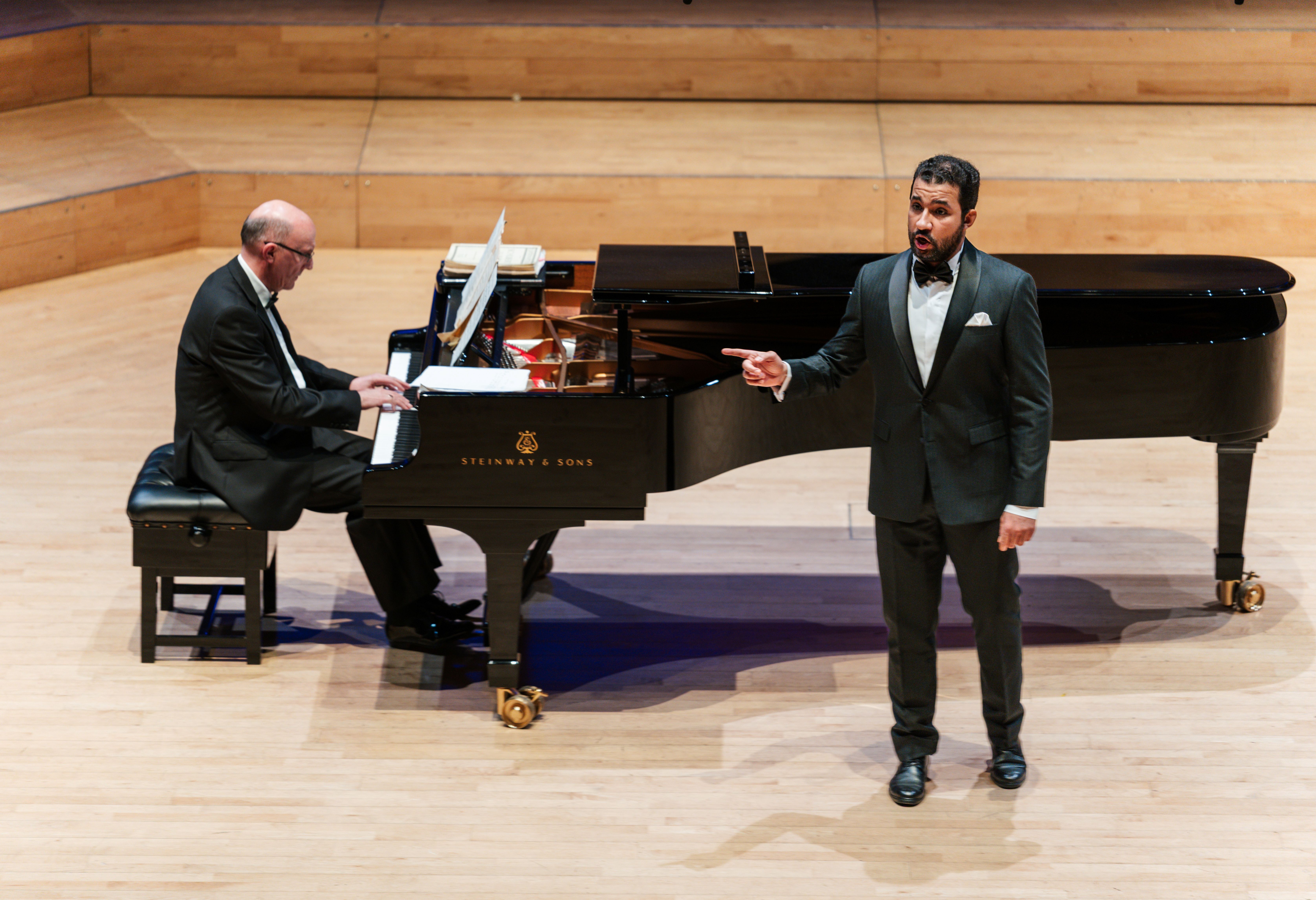 Voice student performing with piano accompanist in concert hall