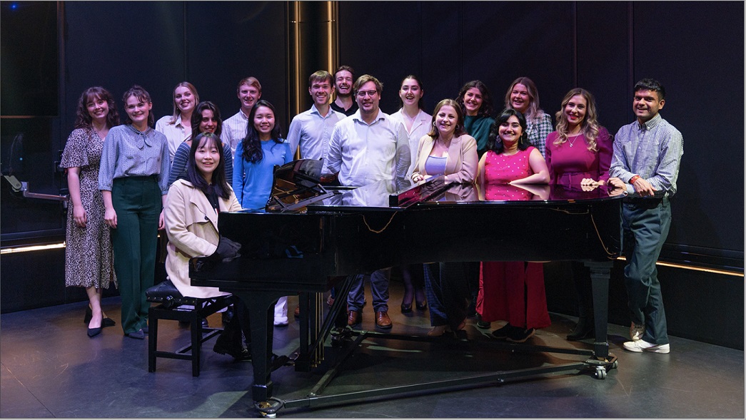 RNCM Songsters standing around a piano