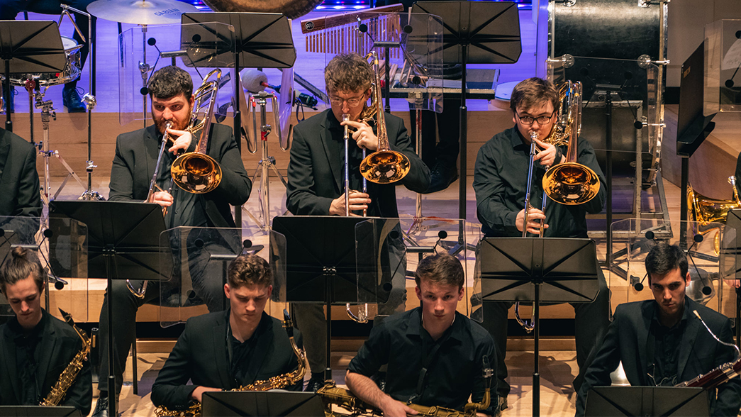 Three trumpet players perform in the RNCM Wind Orchestra.