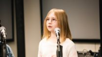 RNCM Young Artist standing by microphone