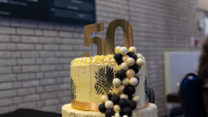A cake with the number 50 on it sits on a table. 