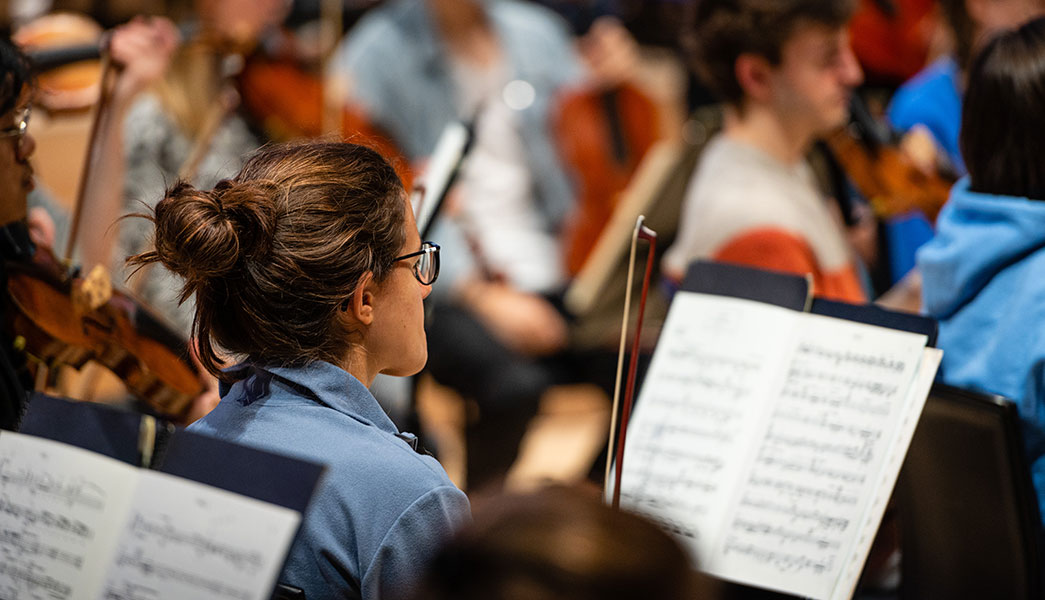 A string player following the music in the RNCM Symphony Orchestra.