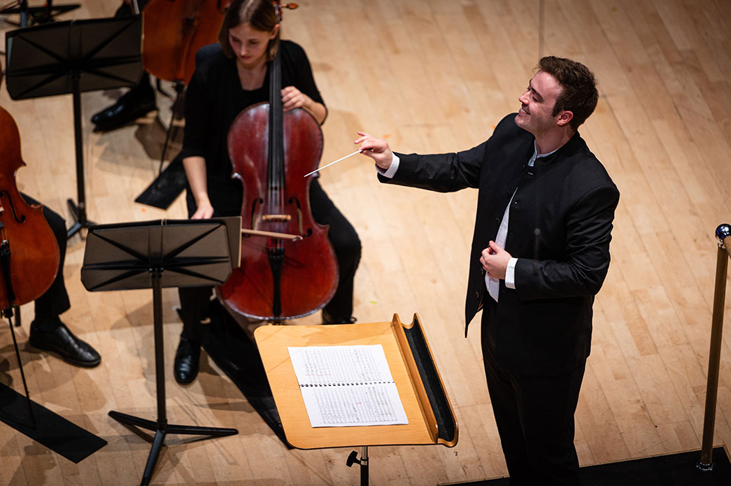 Robin Wallington conducts an orchestra.