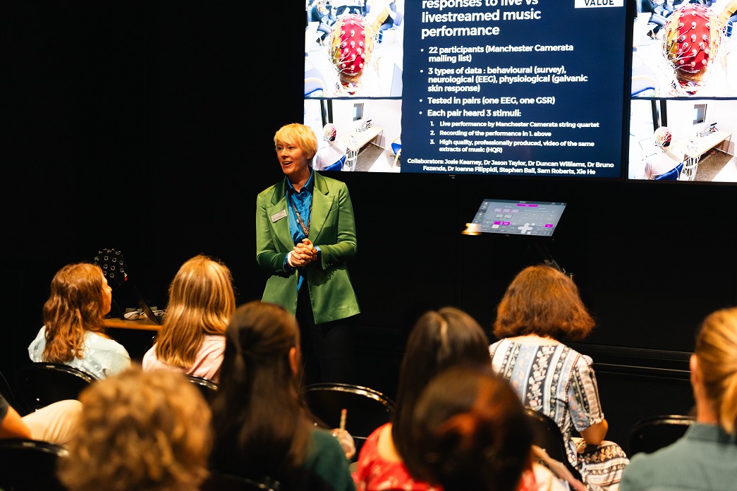 RNCM tutor talks to a group of people about research at the RNCM