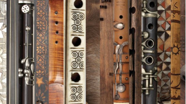 Antique woodwind instruments lie together side by side. 