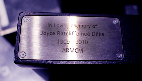 A seat plaque which reads "In loving memory of Joyce Ratcliff nee Dilks 1909 - 2010 ARMCM"