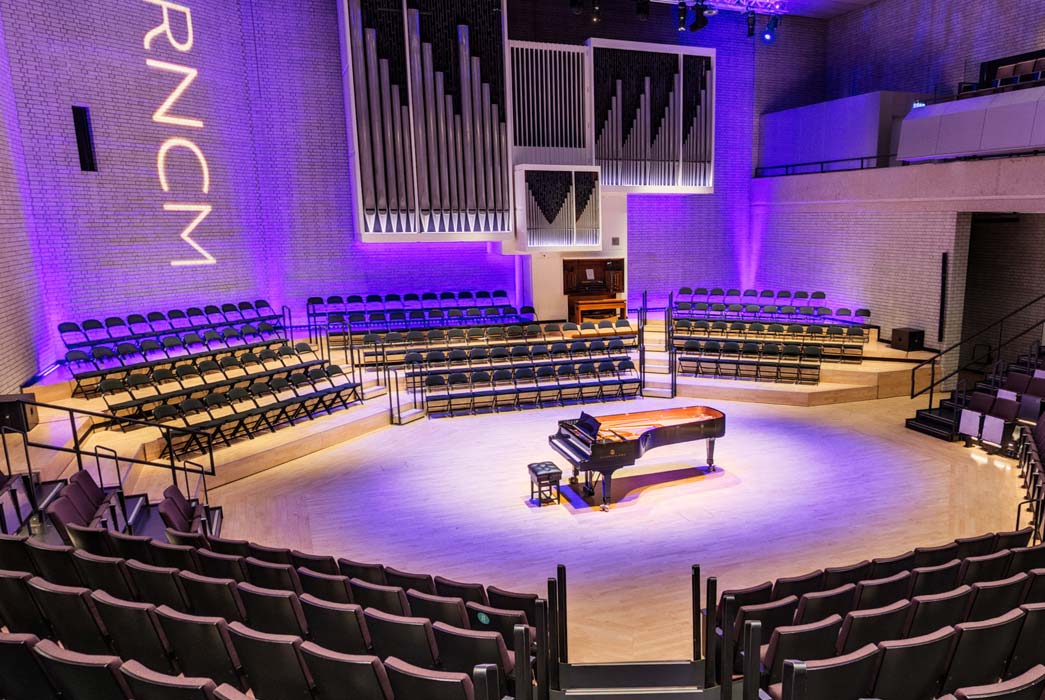 A piano stands in the middle of the stage in the RNCM theatre.