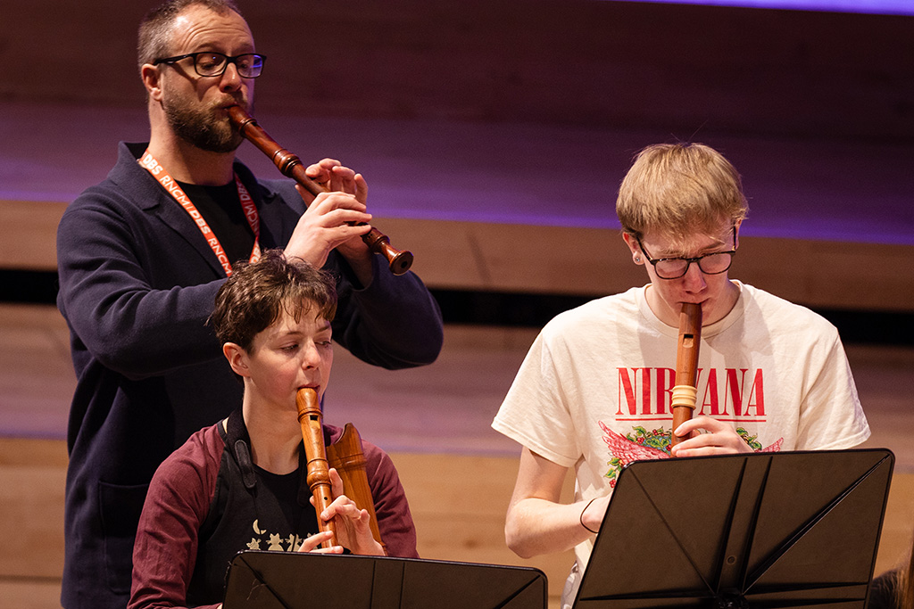 Young projects students play recorders.