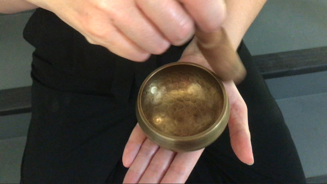 hands holding a singing bowl