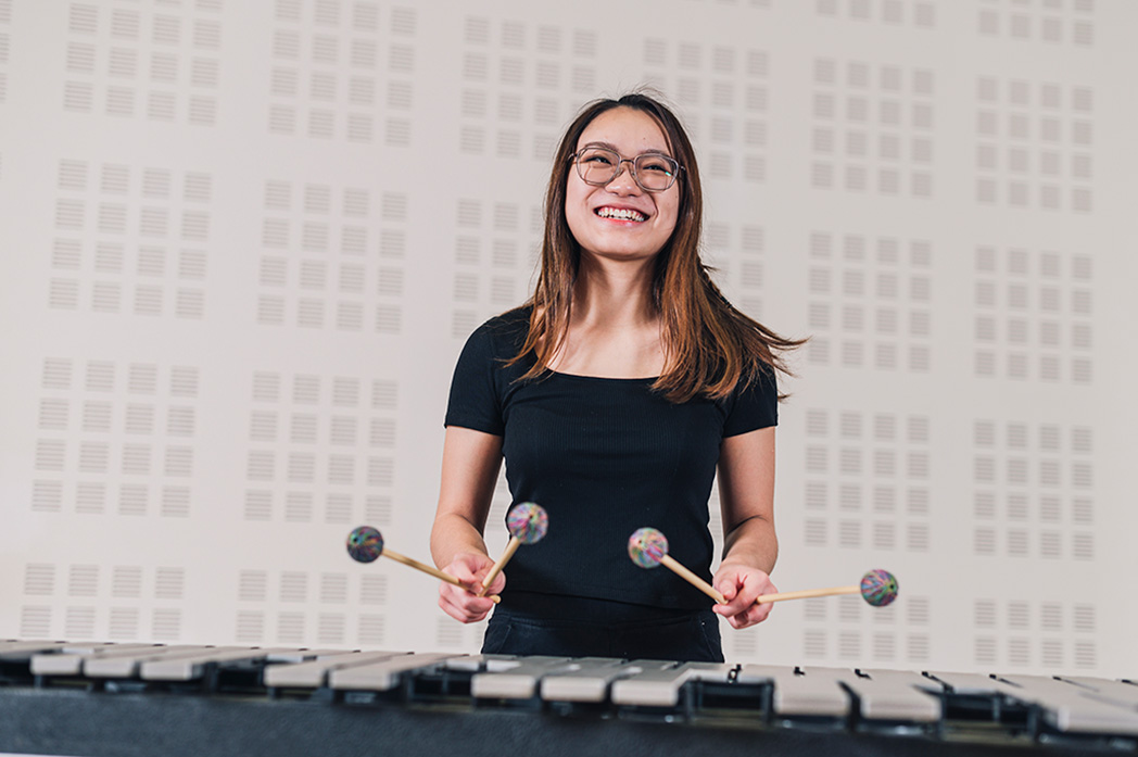 Girl playing xylophone and smiling. 