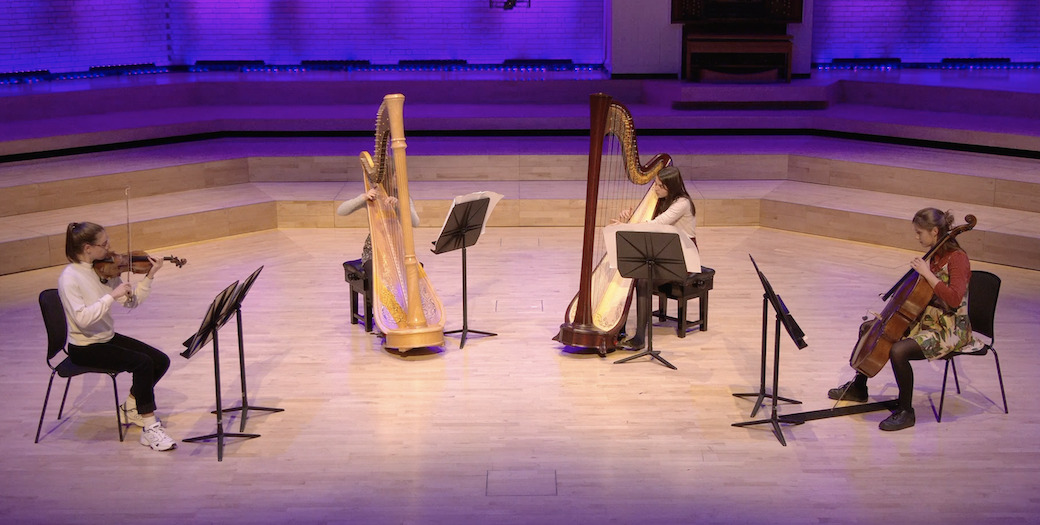 a quartet playing on stage - 2 harps, a cello and a violin