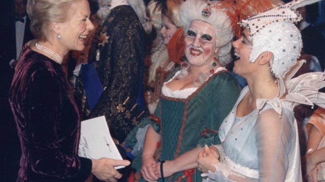 Three women laughing, dressed in Opera costumes and wigs.