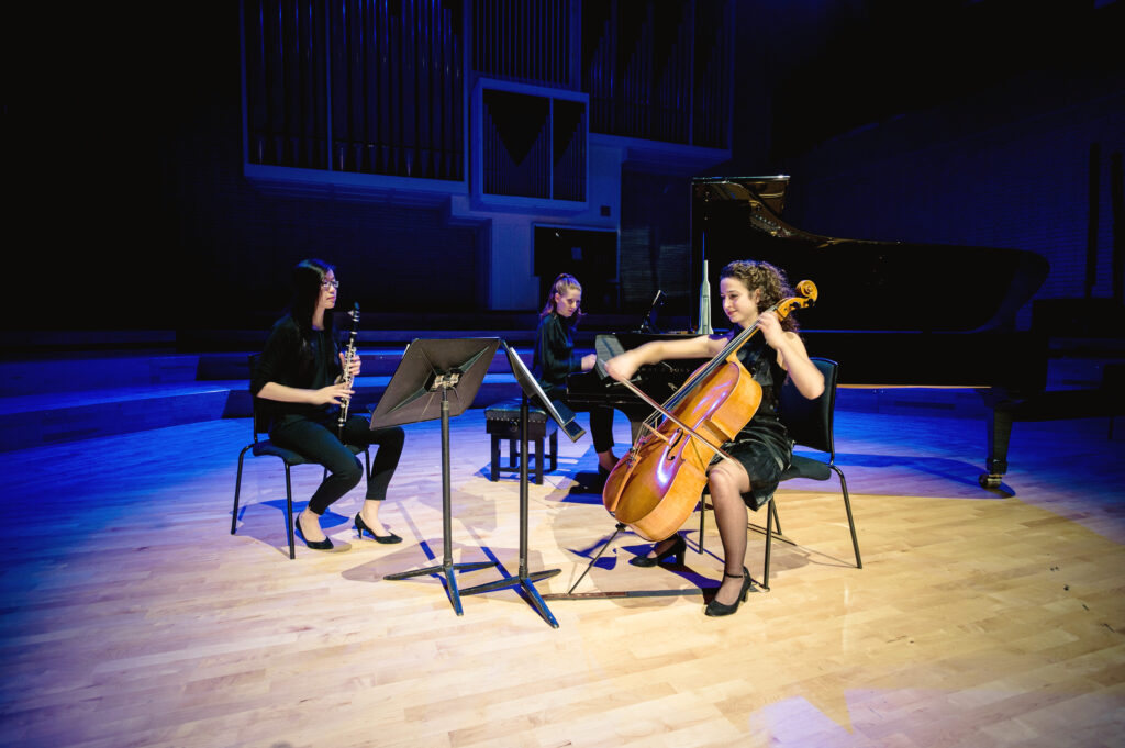 Three RNCM students perform on stage.